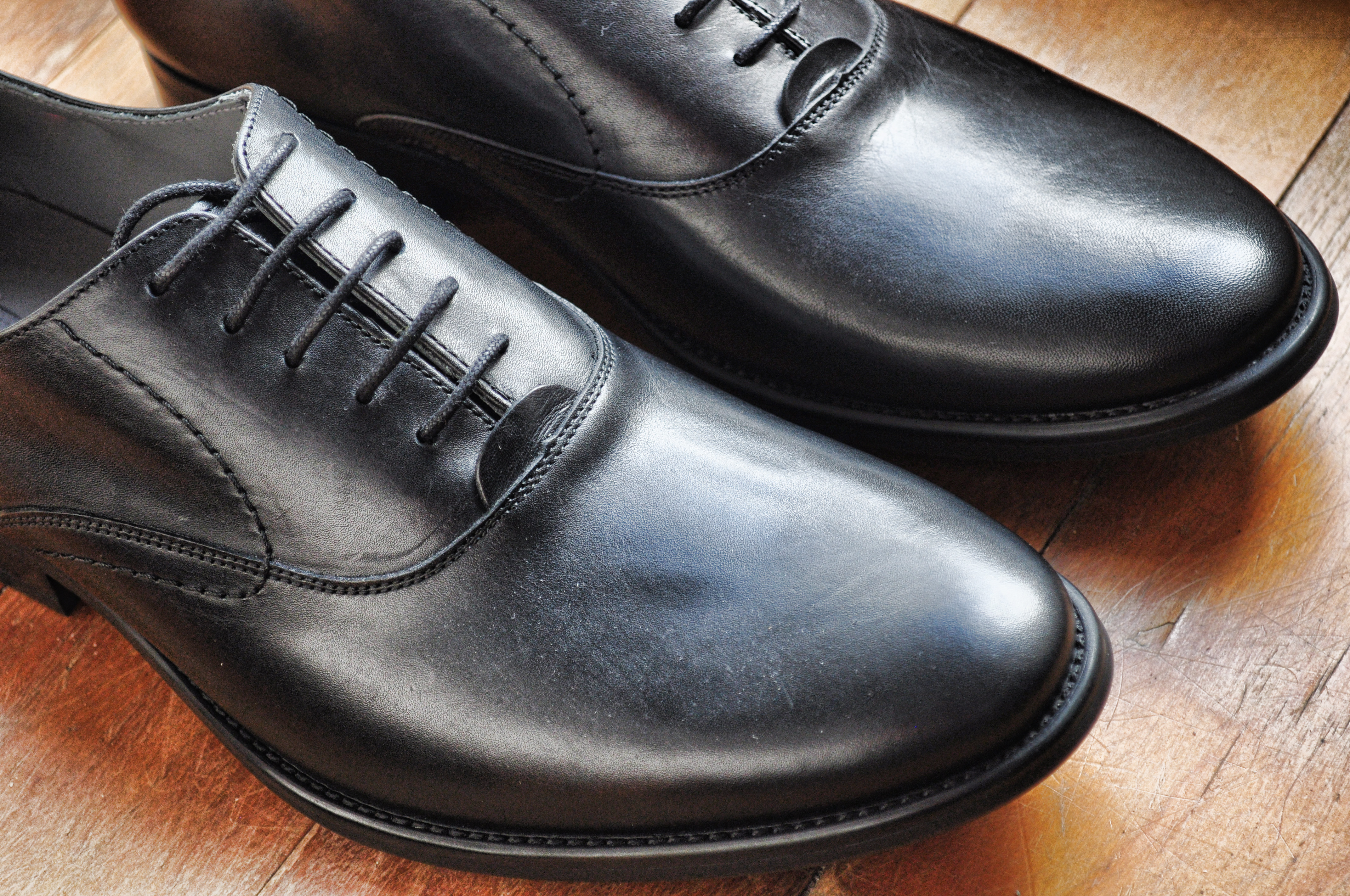 HAWKYN black leather shoe in a dark studio setting